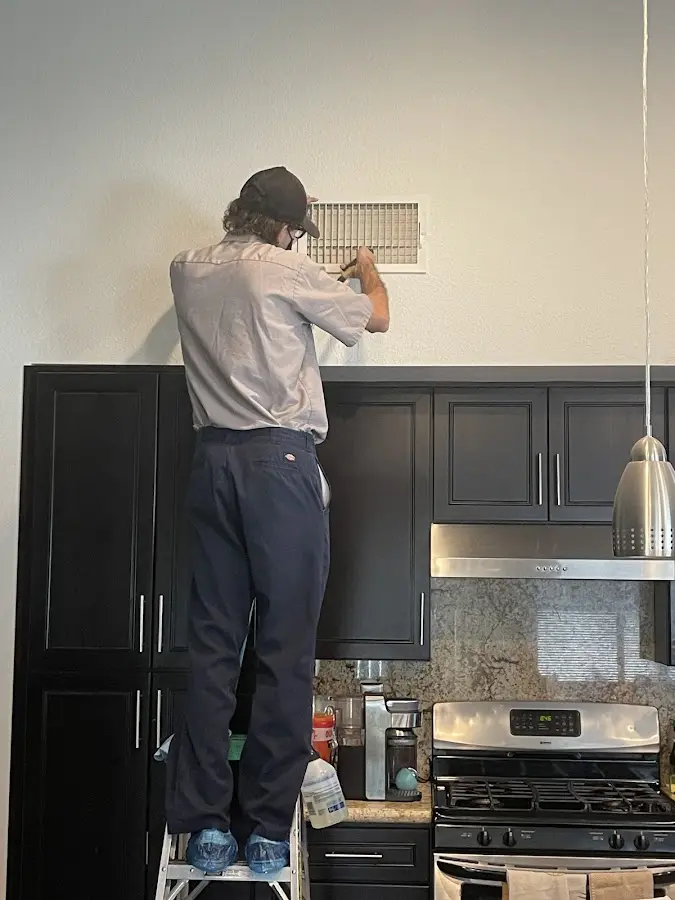 Technician inspecting an air vent during HVAC service in Imperial